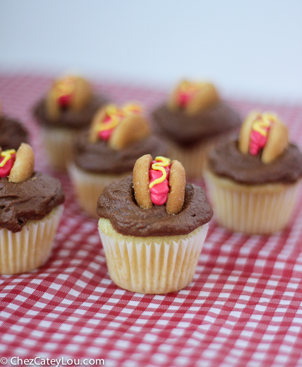 Mini Hot Dog Cupcakes - yellow cupcakes are topped with chocolate frosting and then decorated with a hot dog!  | ChezCateyLou.com