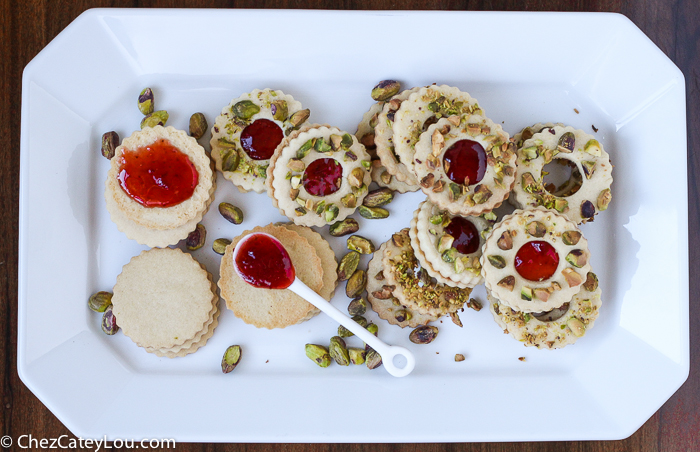 Pistachio Wreath Cookies - festive Linzer cookies decorated to look like a Christmas wreath! | ChezCateyLou.com